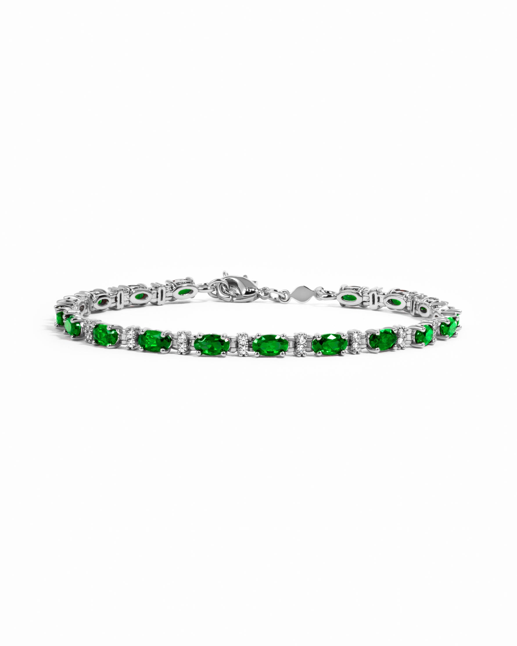 Silver tennis bracelet with alternating oval emerald and round white stones.