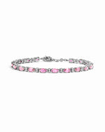 Silver tennis bracelet with oval pink sapphires and diamond accents.