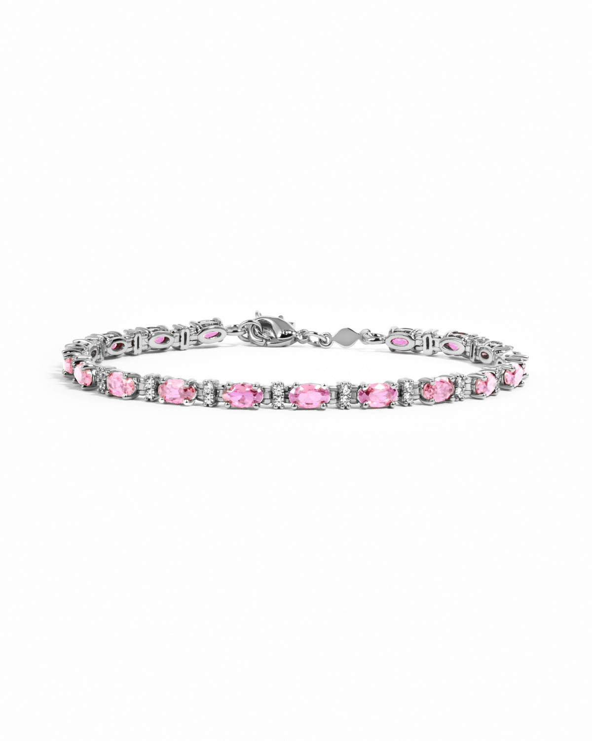 Silver tennis bracelet with oval pink sapphires and diamond accents.