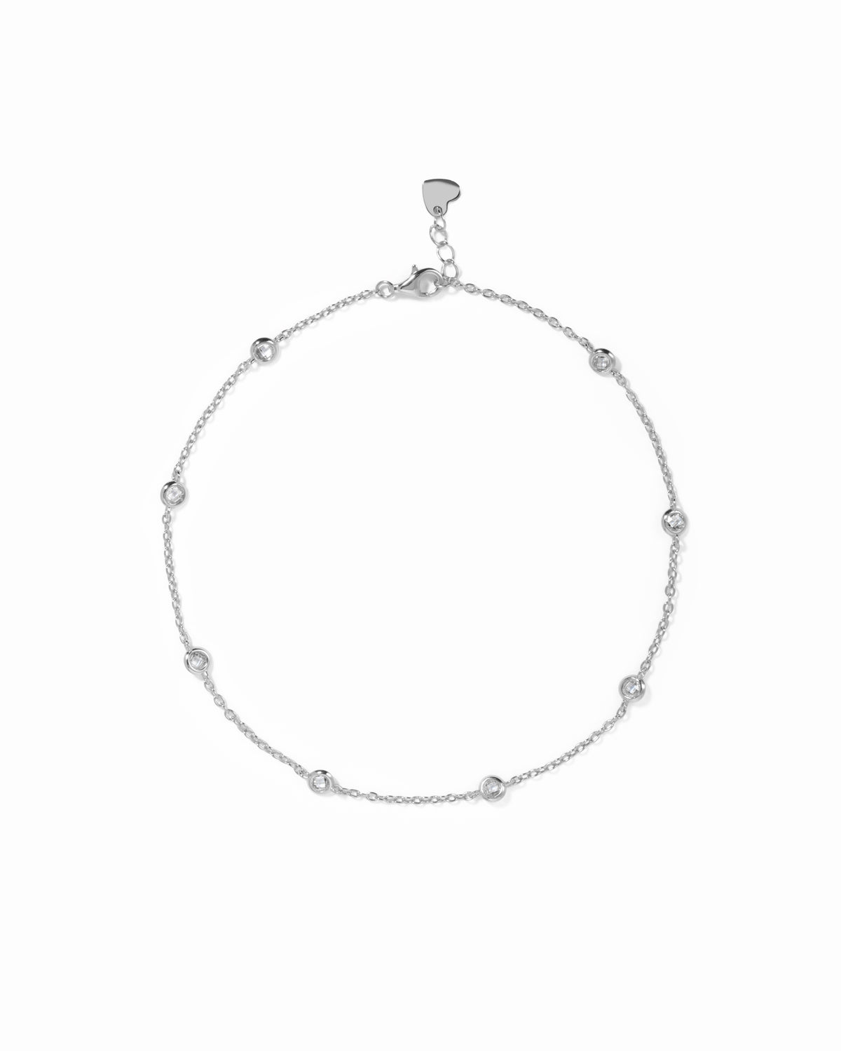 Bezel Set Station Anklet in silver finish, with round bezel-set stones, lobster clasp and heart-shaped end tag.