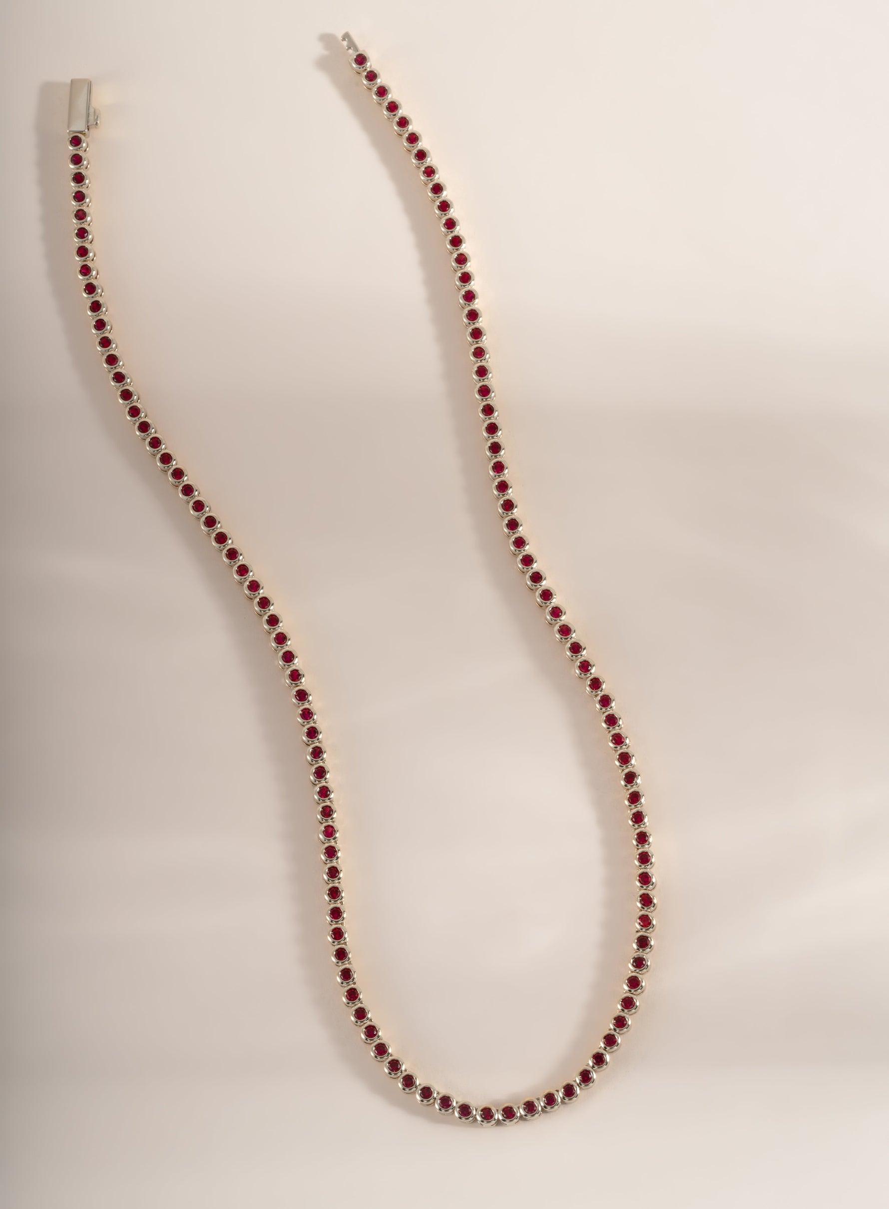 Silver Ruby Bezel Tennis Necklace by Sami Jewels featuring evenly spaced ruby gemstones along a sleek silver chain.