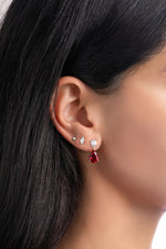 Silver Camille Ruby Pear Drop Earrings by Sami Jewels showcased on a model, featuring dangling ruby gemstones and a sleek silver setting.