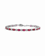 Silver Ruby Tennis Bracelet by Sami Jewels featuring sparkling diamonds and vibrant red rubies on a sleek bracelet.