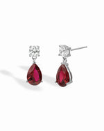 Silver earrings featuring ruby pear-shaped drops from Sami Jewels, showcasing elegant sterling silver jewelry design.