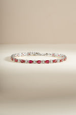 Silver Ruby Tennis Bracelet by Sami Jewels featuring a row of vibrant rubies set in a sleek silver bracelet.