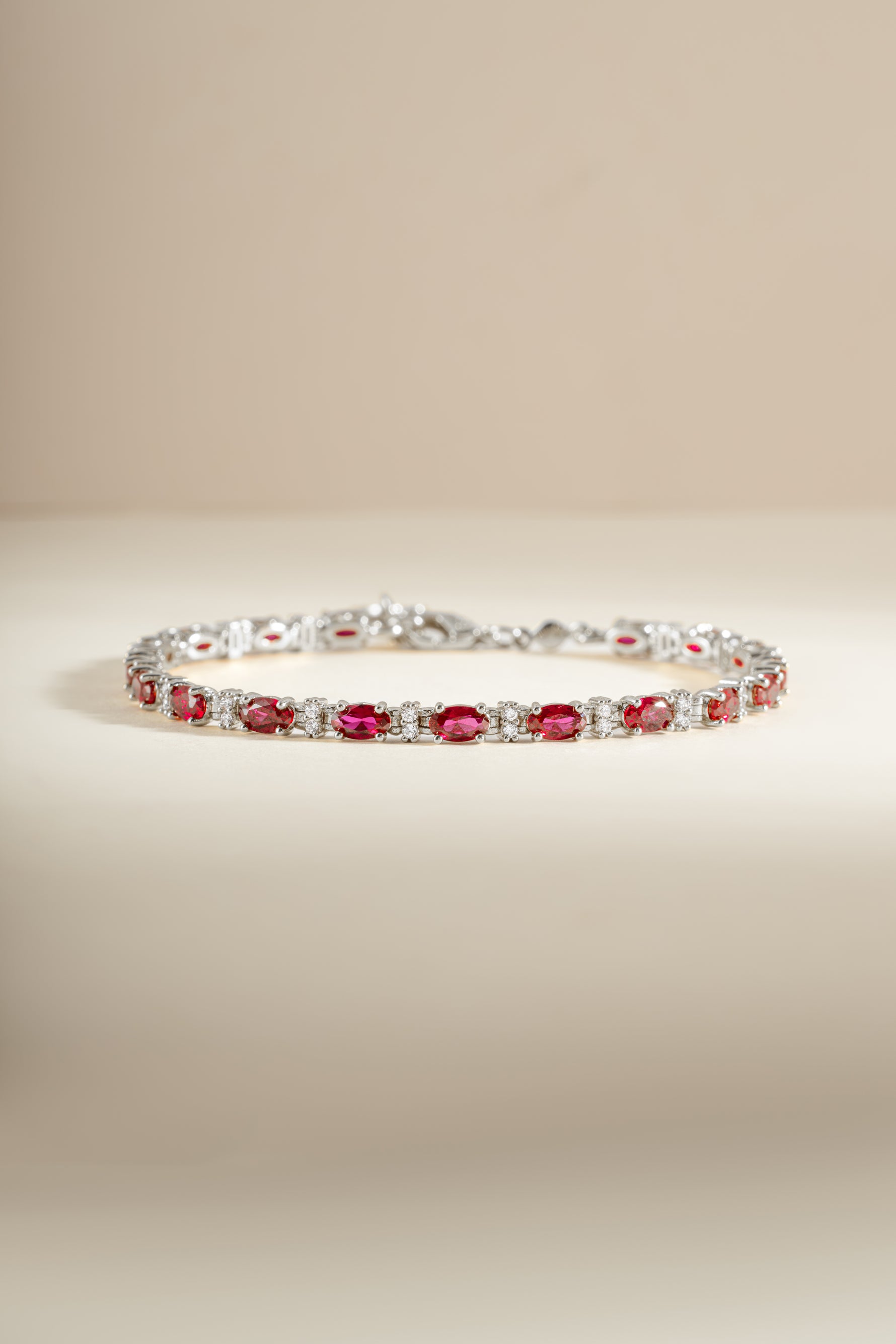 Silver Ruby Tennis Bracelet by Sami Jewels featuring a row of vibrant rubies set in a sleek silver bracelet.