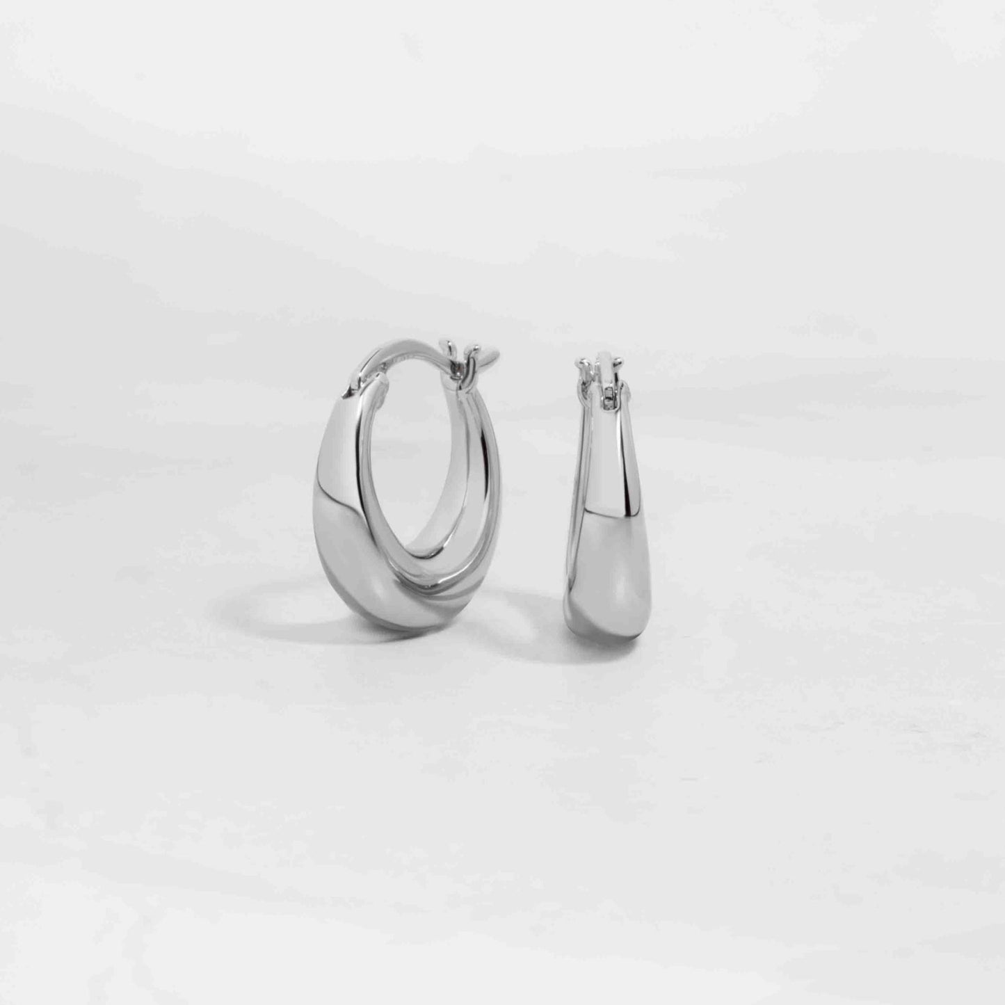 Silver chunky hoop earrings on white background