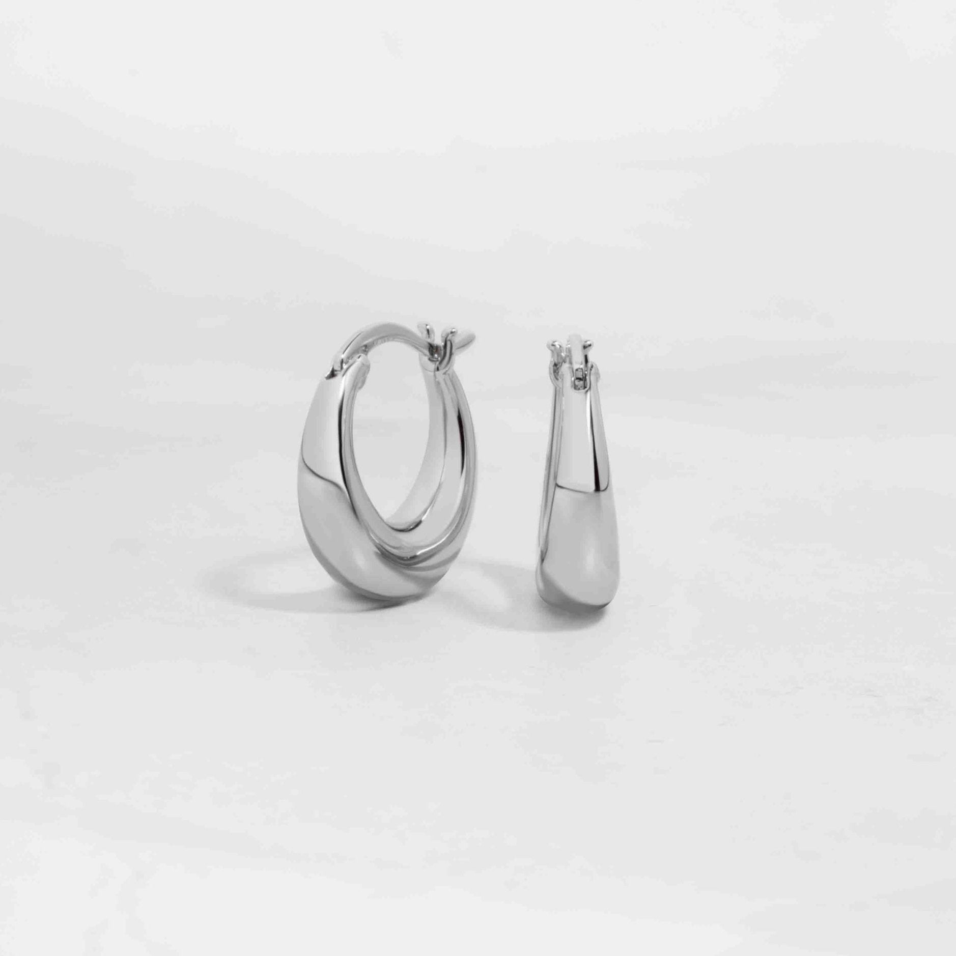 Silver chunky hoop earrings on white background