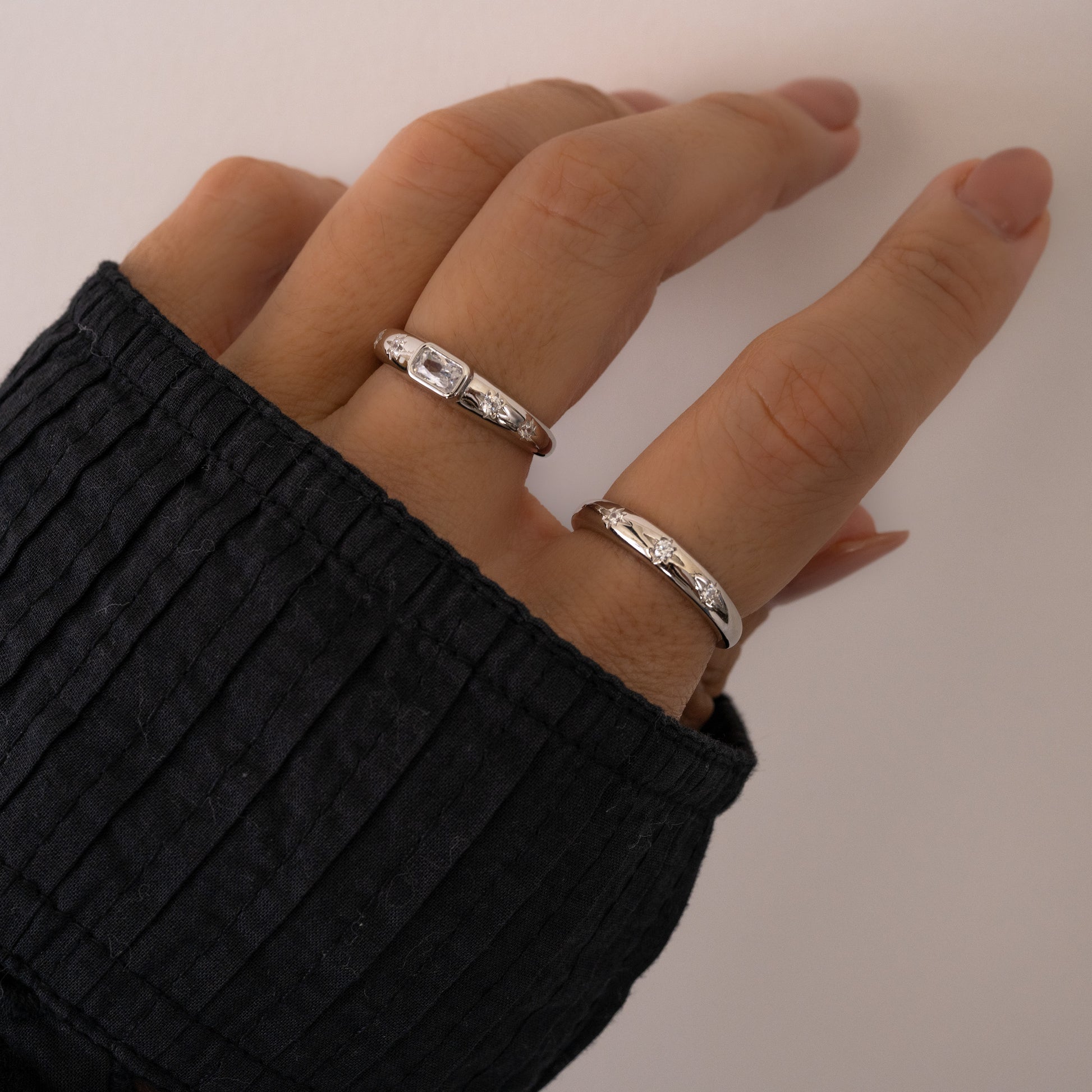 Statement silver star celestial rings for her, showcased on women's middle and pointer fingers. 