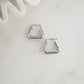 Chunky silver earrings with a bold triangle shape.