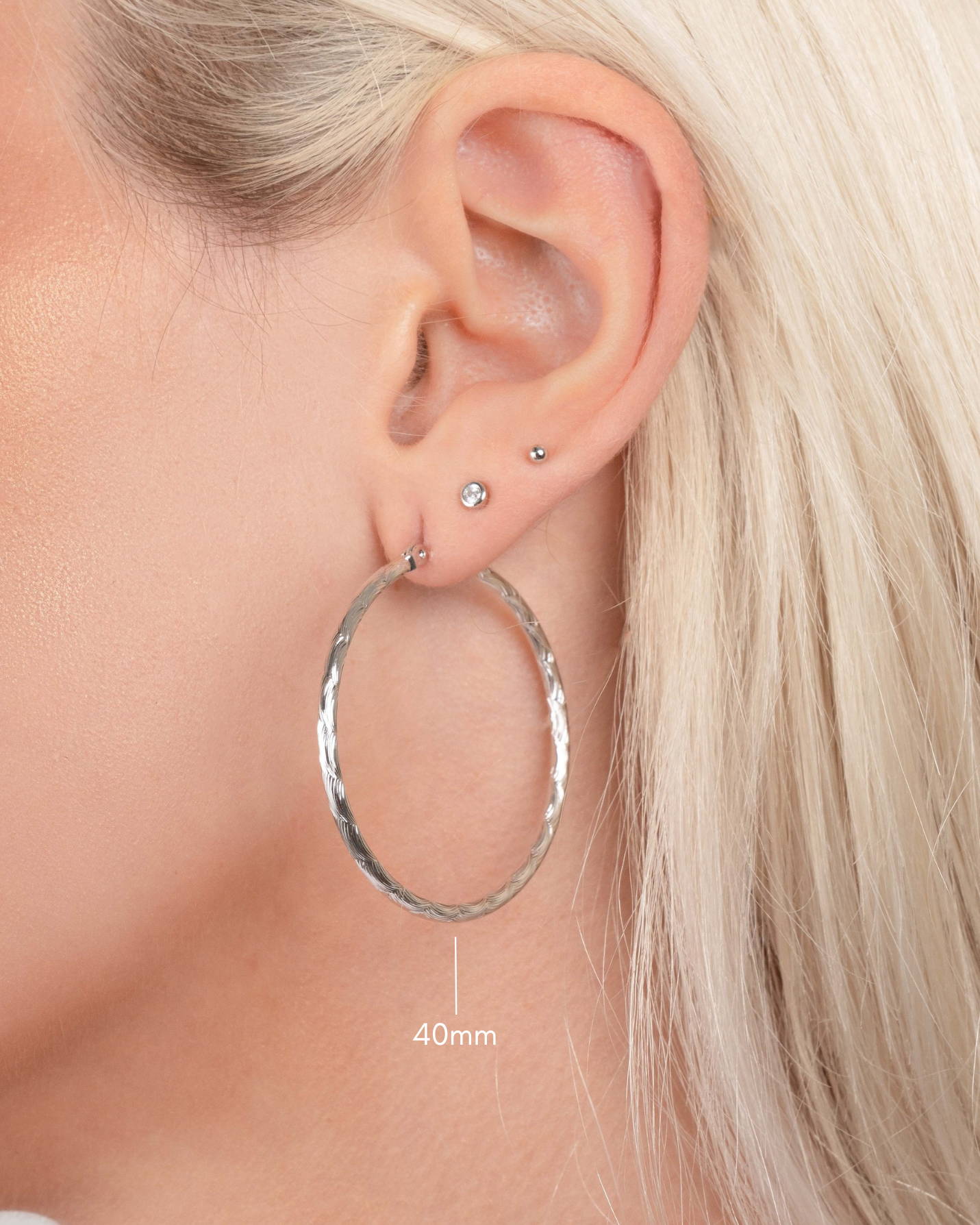 silver textured hoop earrings on model