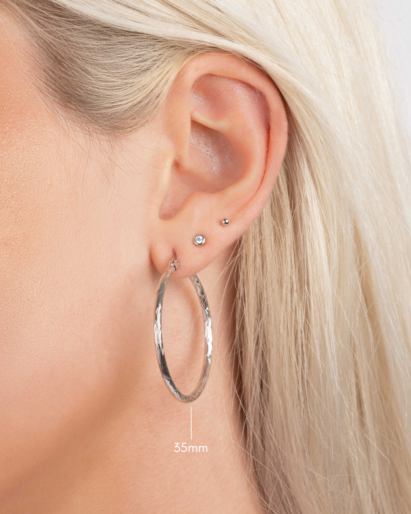 silver textured hoop earrings on model