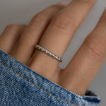 model wearing delicate silver ring, highlighting its fine twisted details. 