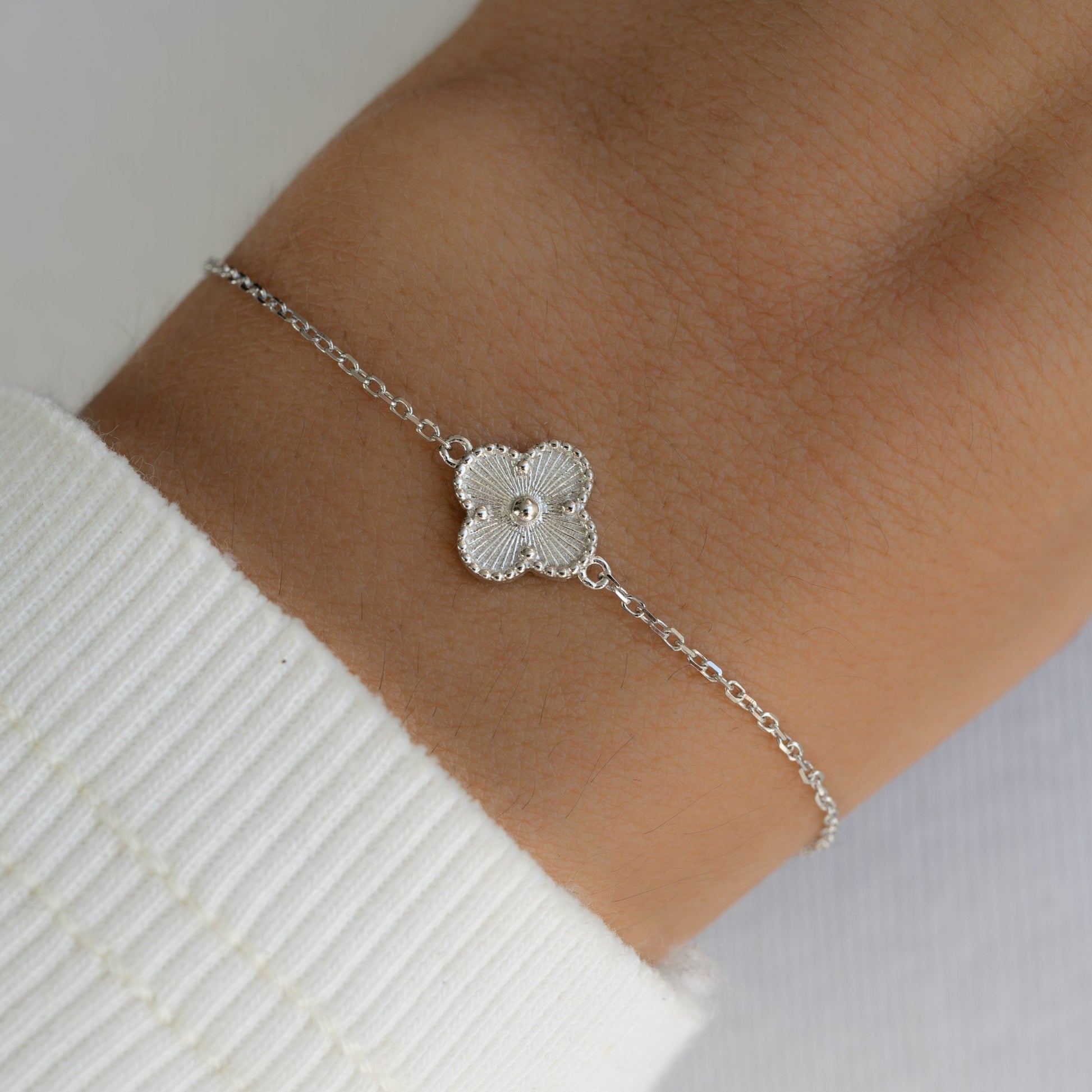 Silver clover bracelet on the wrist of the model