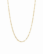 Gold beaded necklace from Sami Jewels displayed on a white background, highlighting its simple and elegant design.