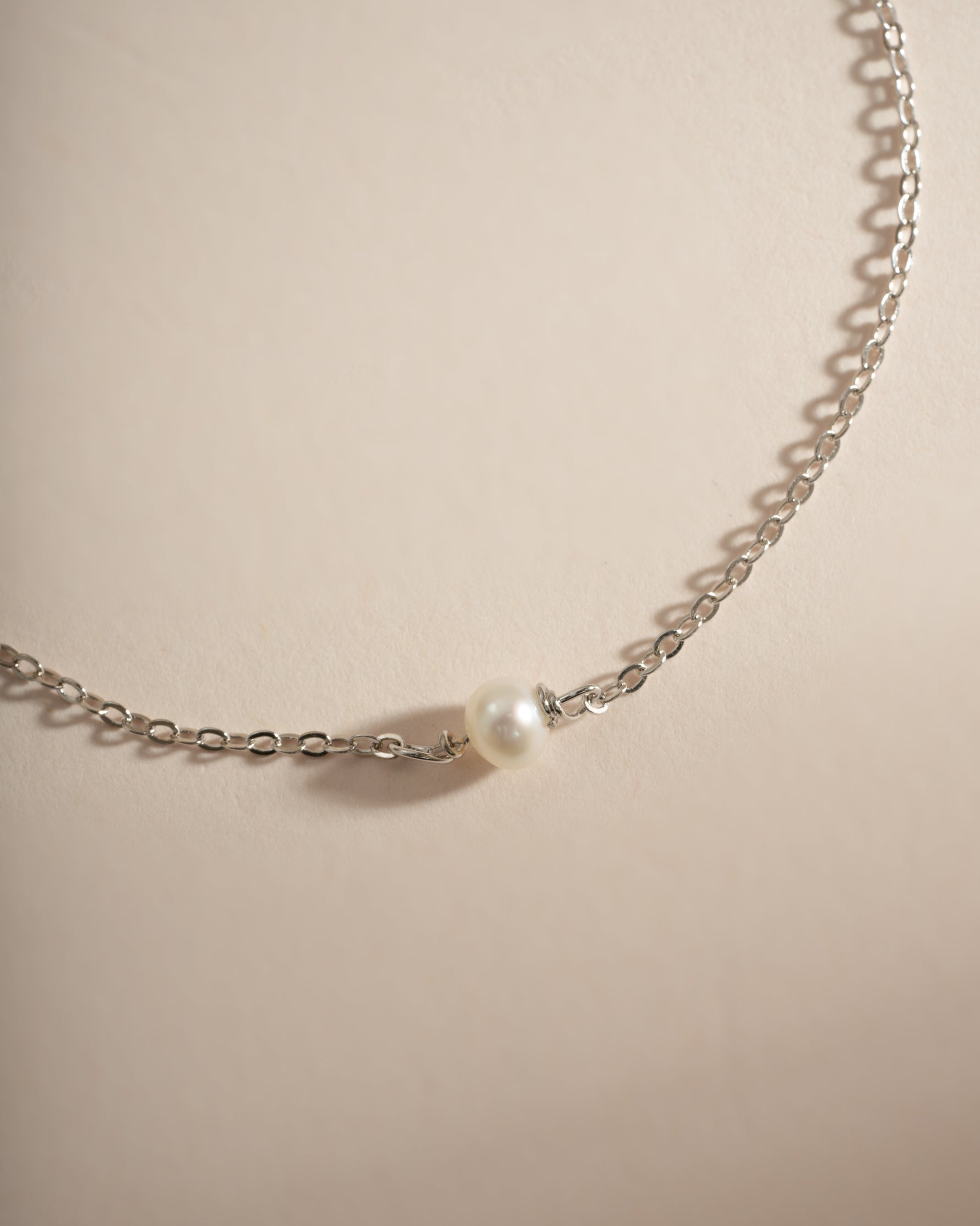 Close-up of Sami Jewels' simple freshwater pearl bracelet made with sterling silver, featuring smooth white pearls on a delicate chain.
