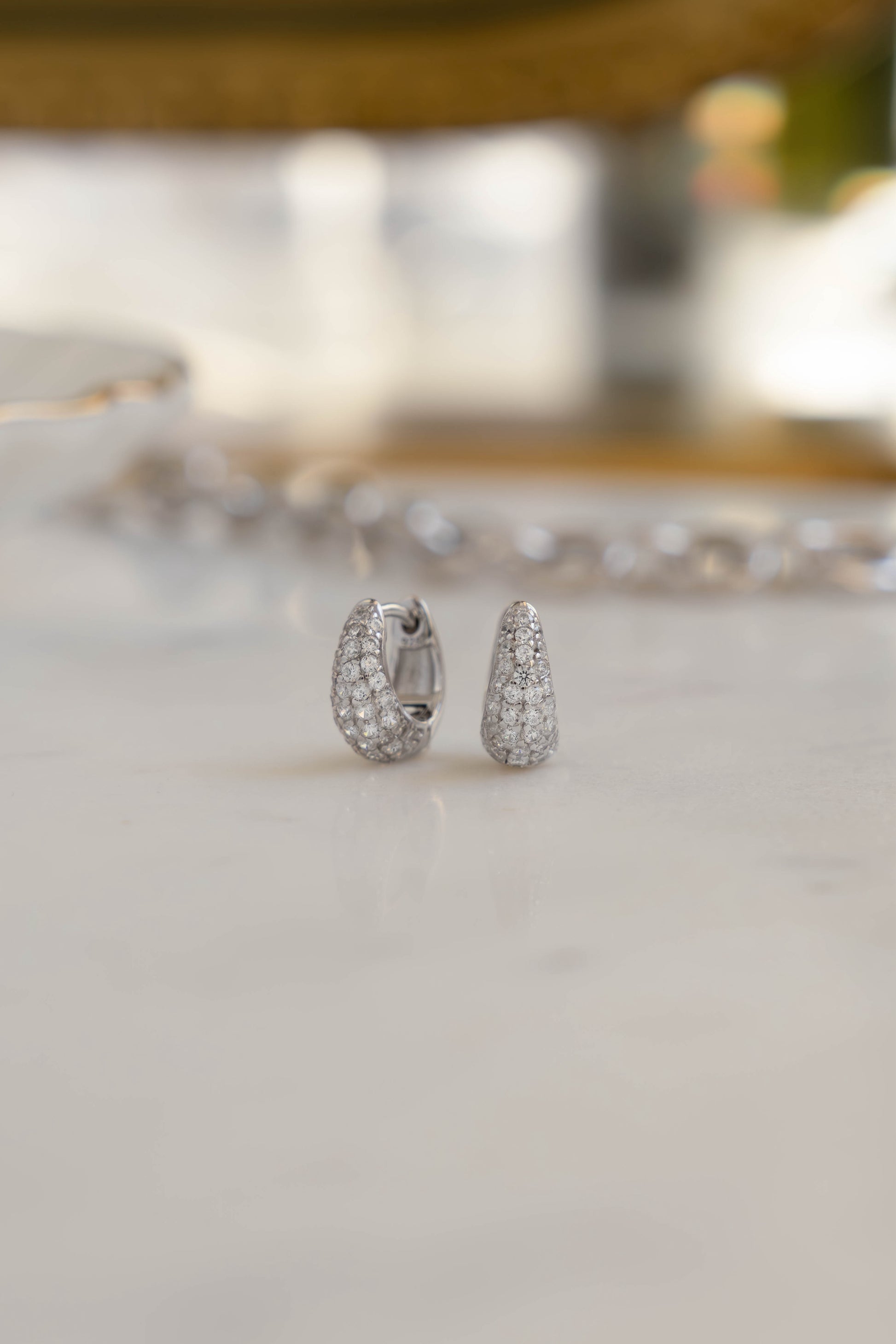 Sterling silver bridal hoop earrings with tiny pave diamonds on marble background