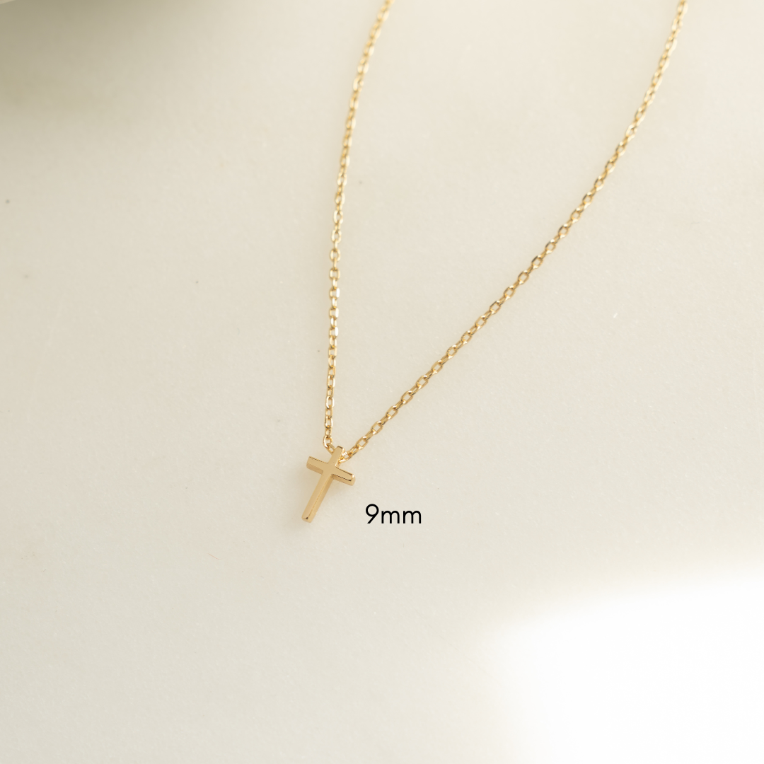 Small tiny 9mm plain cross necklace on white background