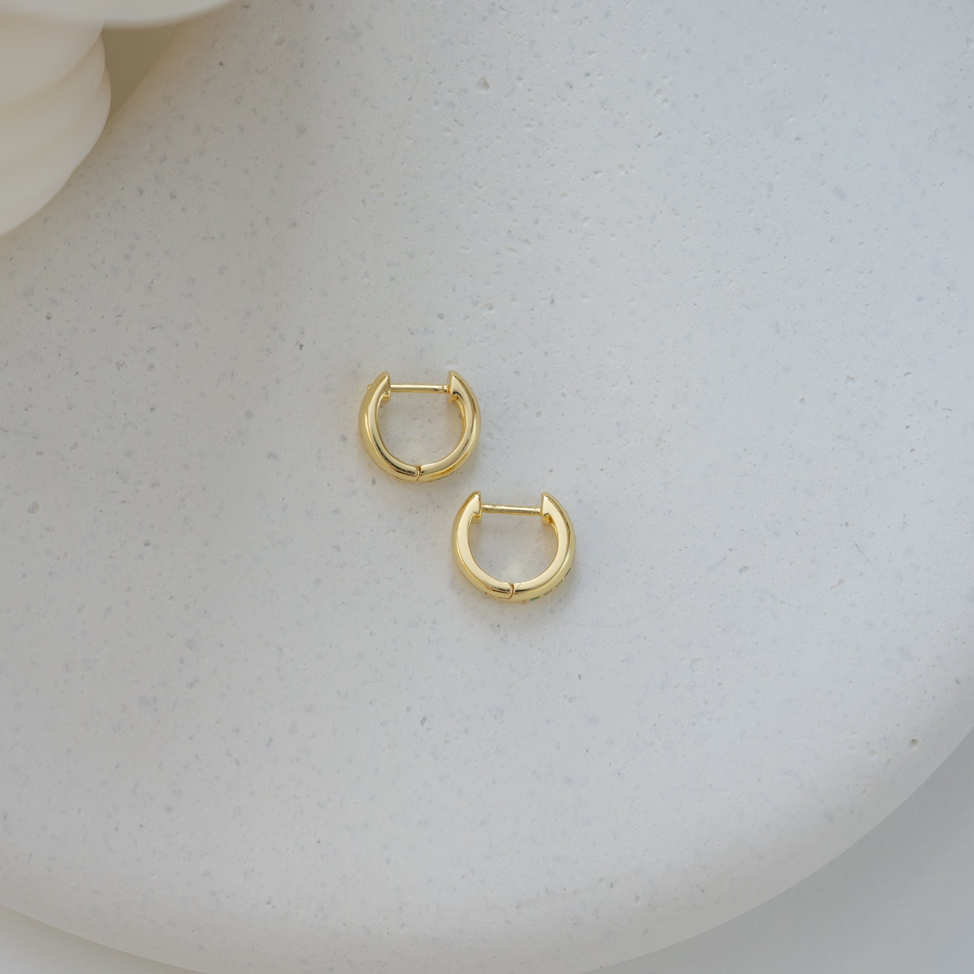 gold minimalist emerald hoop earrings displayed on a white background.