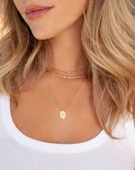 Gold Small Paperclip Necklace from Sami Jewels displayed in a layered necklace stack on a model.