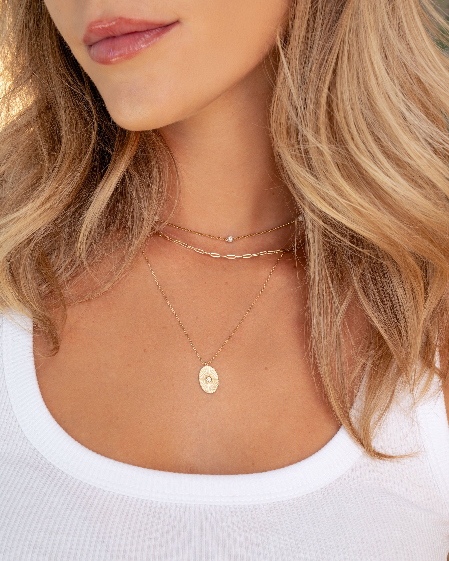 Gold Small Paperclip Necklace from Sami Jewels displayed in a layered necklace stack on a model.