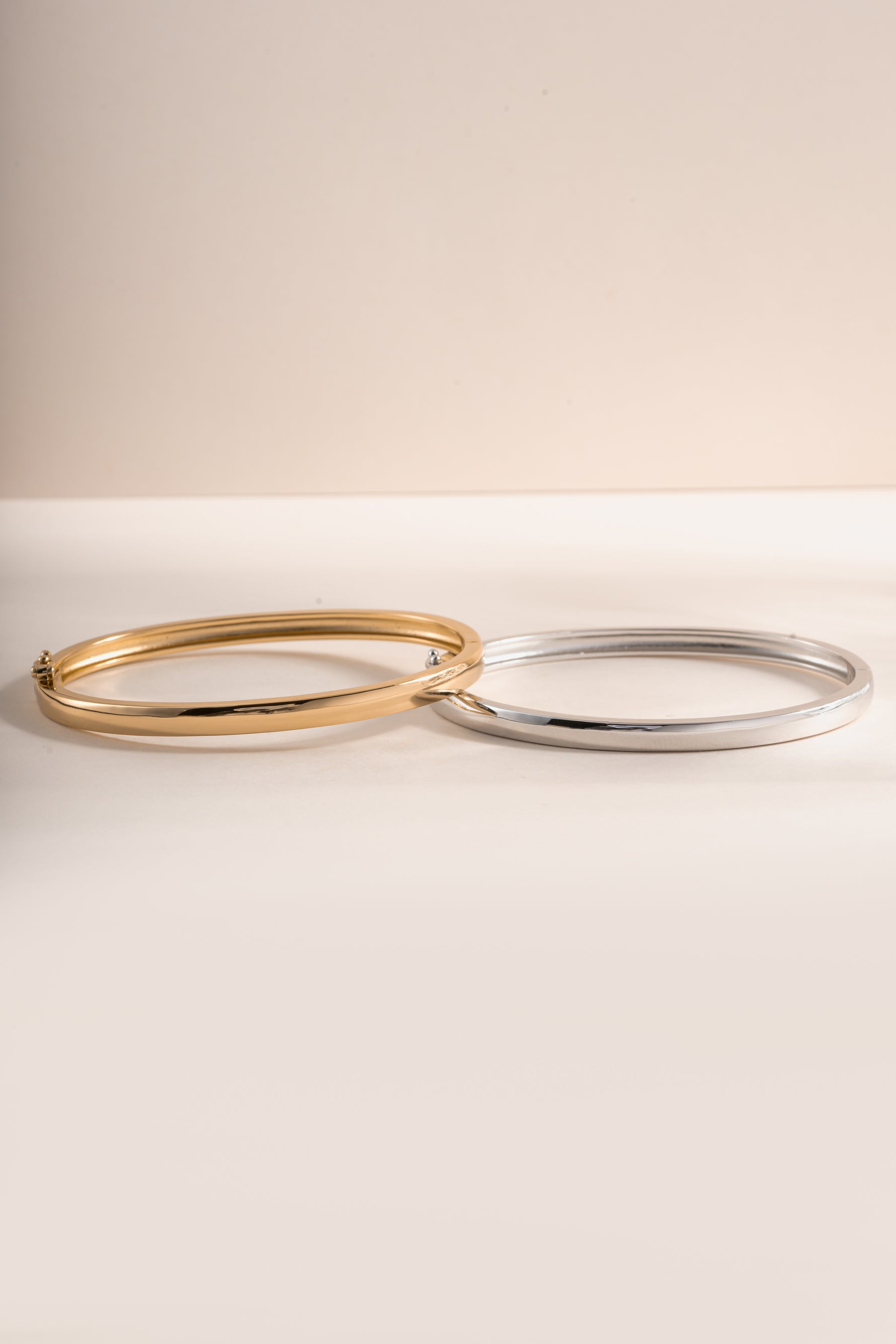 Gold and silver solid bangle bracelet from Sami Jewels with a sleek, polished design, shown from the front view.