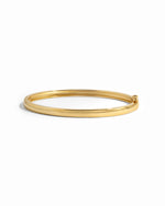 Gold solid bangle bracelet from Sami Jewels with a smooth, polished finish on a white background.