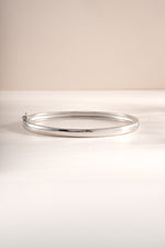 Silver solid bangle bracelet by Sami Jewels, featuring a smooth, polished design displayed from the front view.
