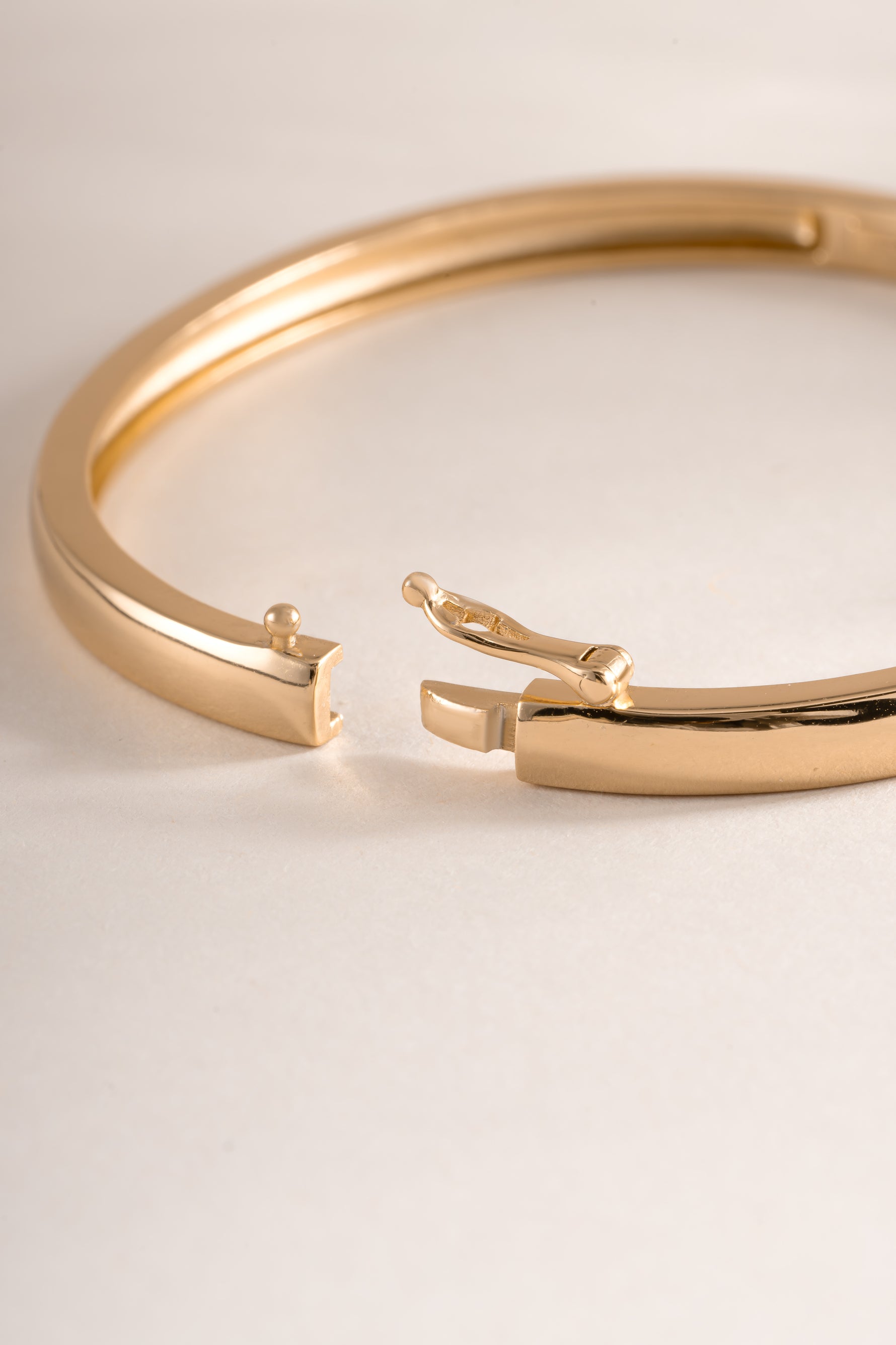 Gold solid bangle bracelet by Sami Jewels featuring a sleek closure style and smooth, polished finish.
