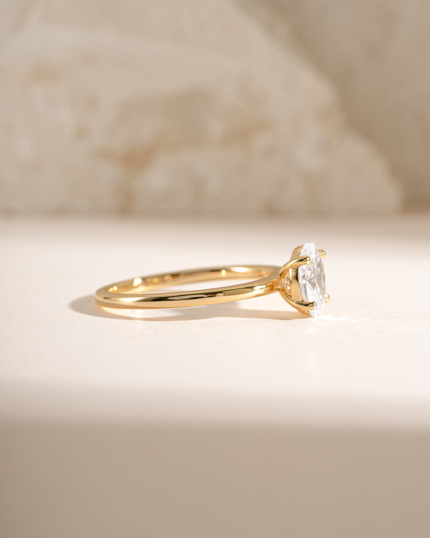 Gold solitaire oval ring from Sami Jewels, side view showcasing the elegant oval-shaped gemstone setting.