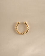 Gold spiral ear cuff earring by Sami Jewels, shown from top view, stylish and modern jewelry accessory for the ear.