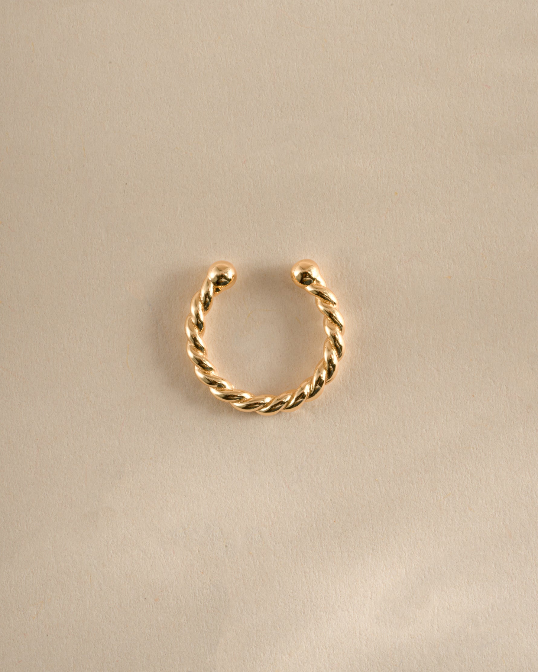 Gold spiral ear cuff earring by Sami Jewels, shown from top view, stylish and modern jewelry accessory for the ear.