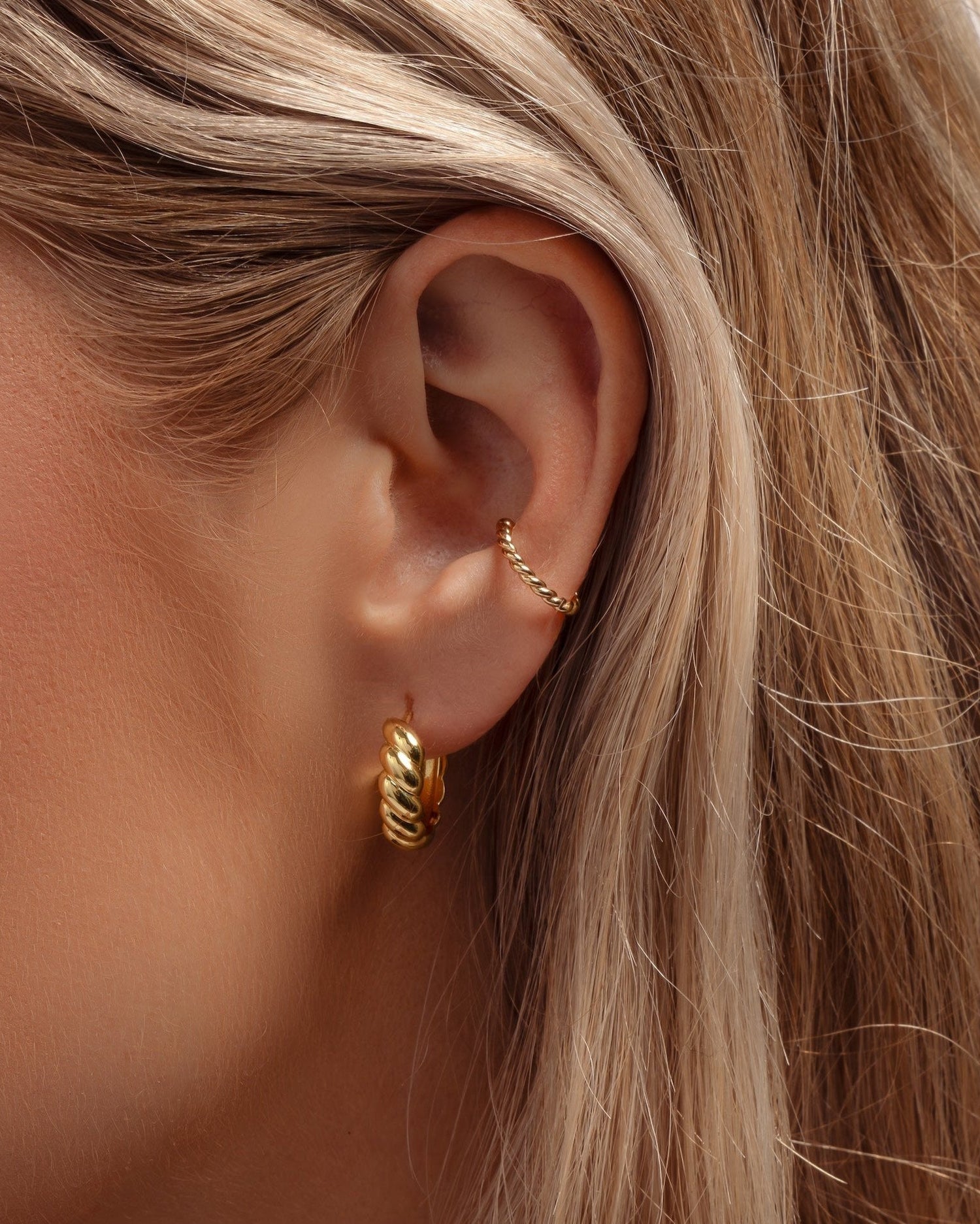 Gold spiral ear cuff earrings by Sami Jewels, shown on a model, stylish and contemporary jewelry accessory for pierced ears.