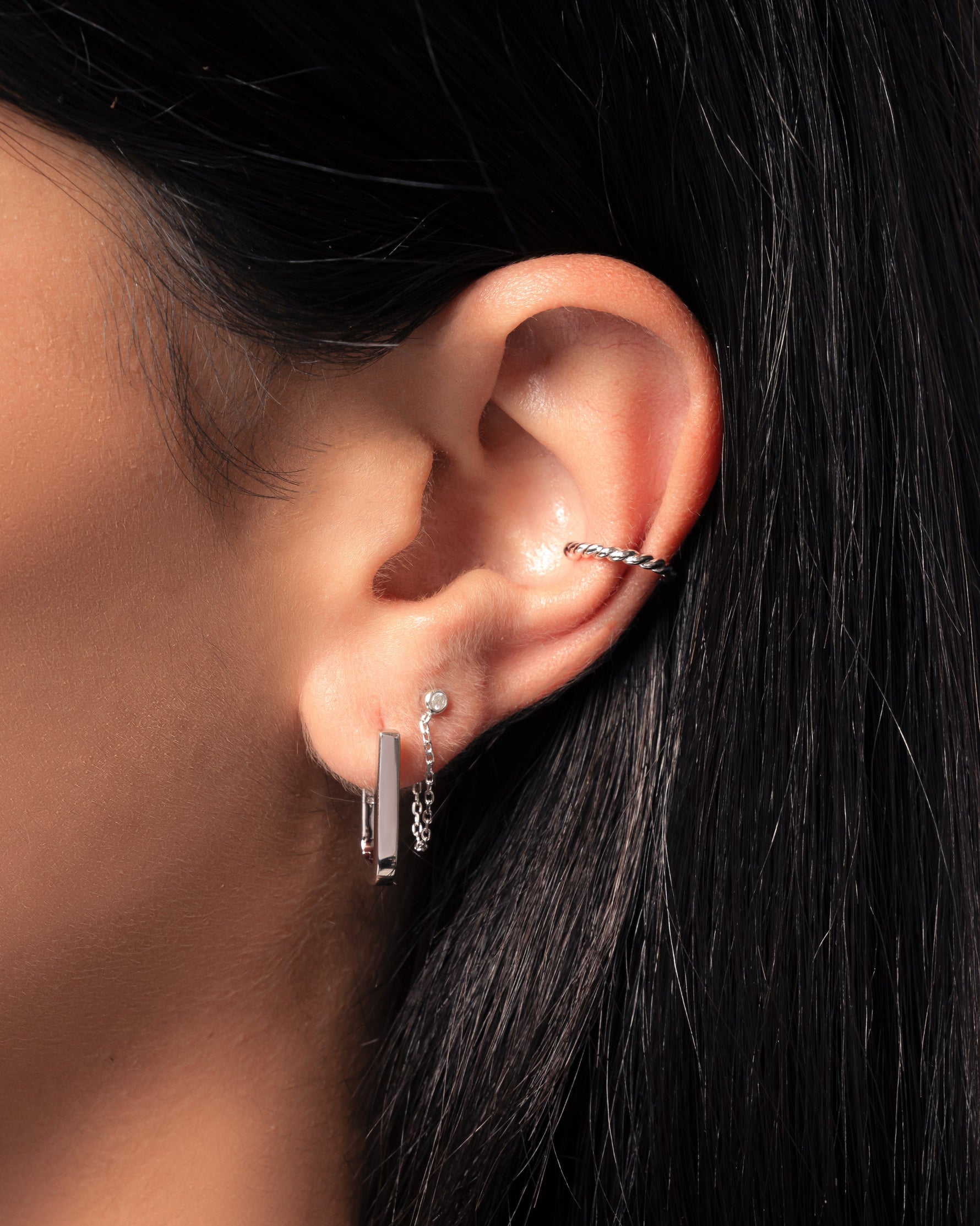 Sterling silver spiral ear cuff earrings by Sami Jewels, shown on a model with a sleek, modern design.