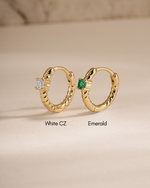 diamond spiral huggies in white cz stone and emerald stone in gold closeup view