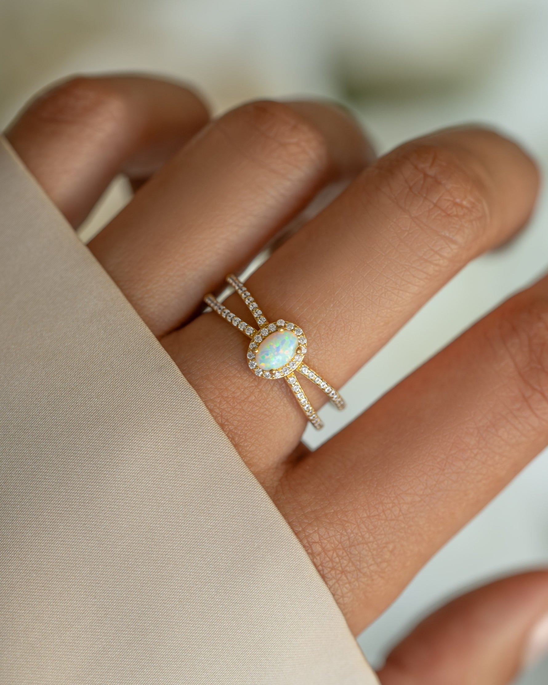 Gold split shank opal ring from Samijewels featuring a central opal gemstone and elegant split band design.