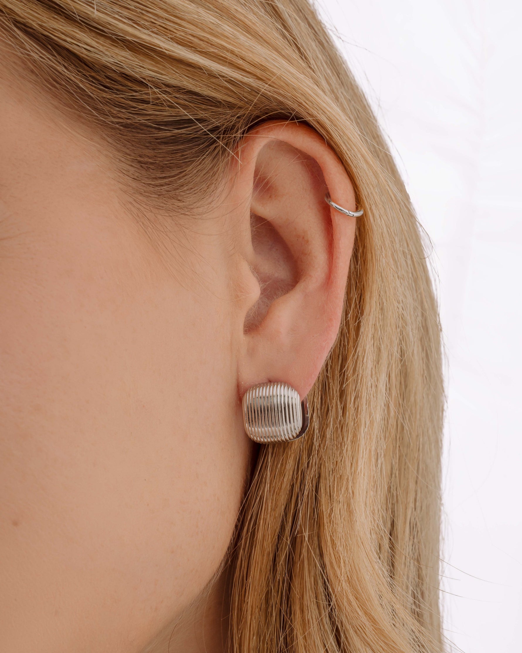 Silver stainless steel SS rounded square statement earrings by Sami Jewels, shown on a model.