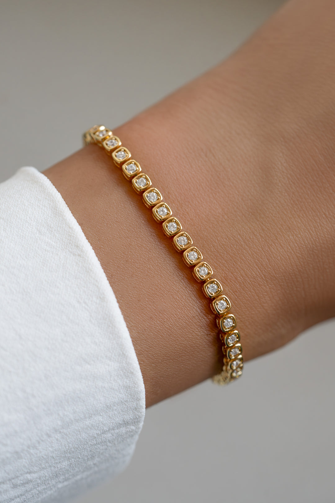 Gold Chloe Tennis Bracelet by SJ Faire, showcasing a sleek square-link design on a model.