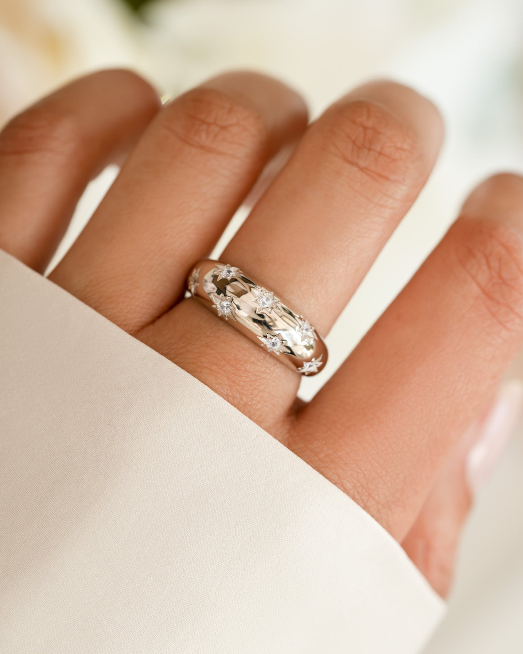 Sterling silver Star Dome Ring by Sami Jewels displayed on a model's hand with a soft focus background.
