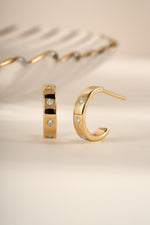 Gold star-studded hoop earrings from Sami Jewels, featuring a stylish design with star accents and classic hoop shape.