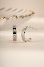 Sterling silver star-studded hoop earrings by Sami Jewels featuring celestial design and shiny finish.