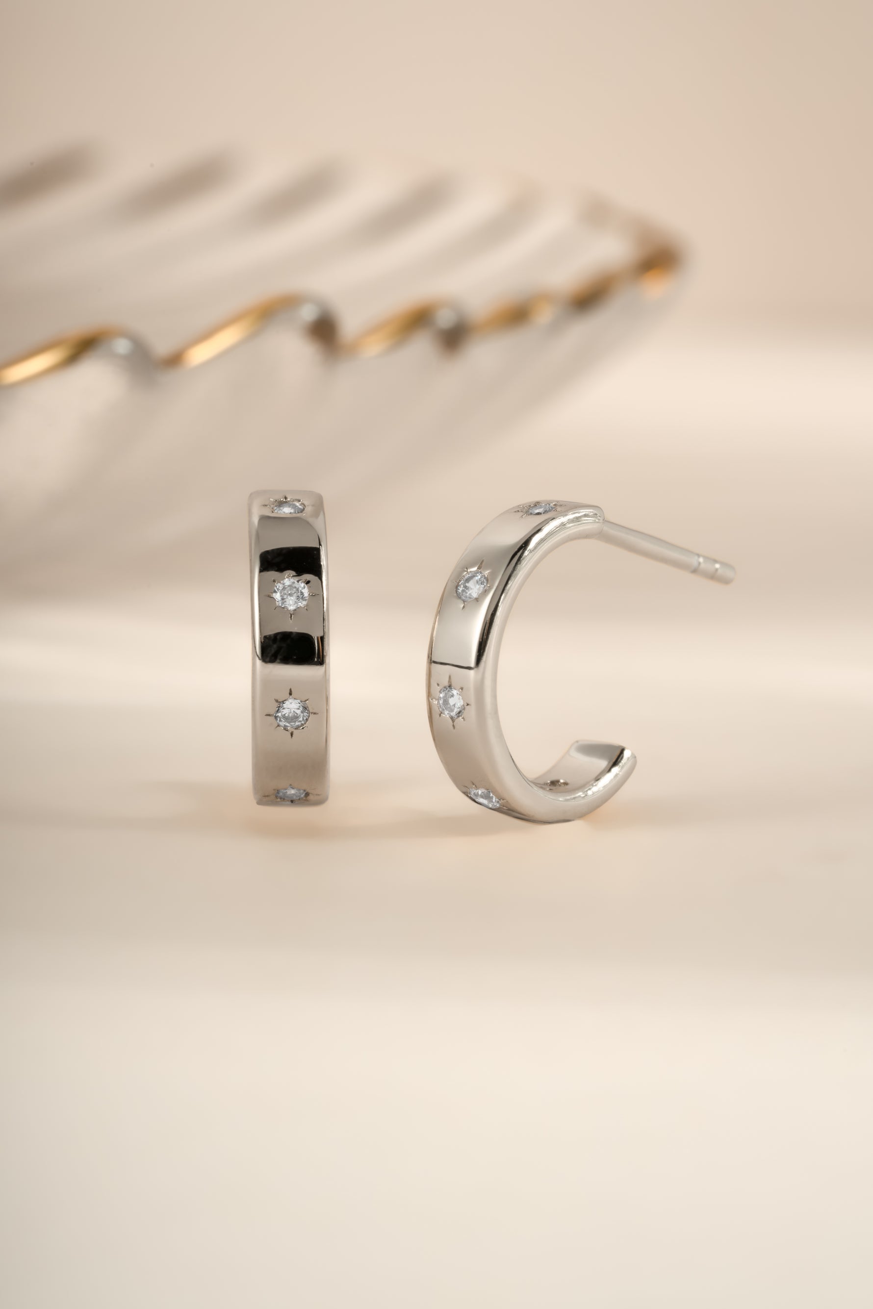 Sterling silver star-studded hoop earrings by Sami Jewels featuring celestial design and shiny finish.