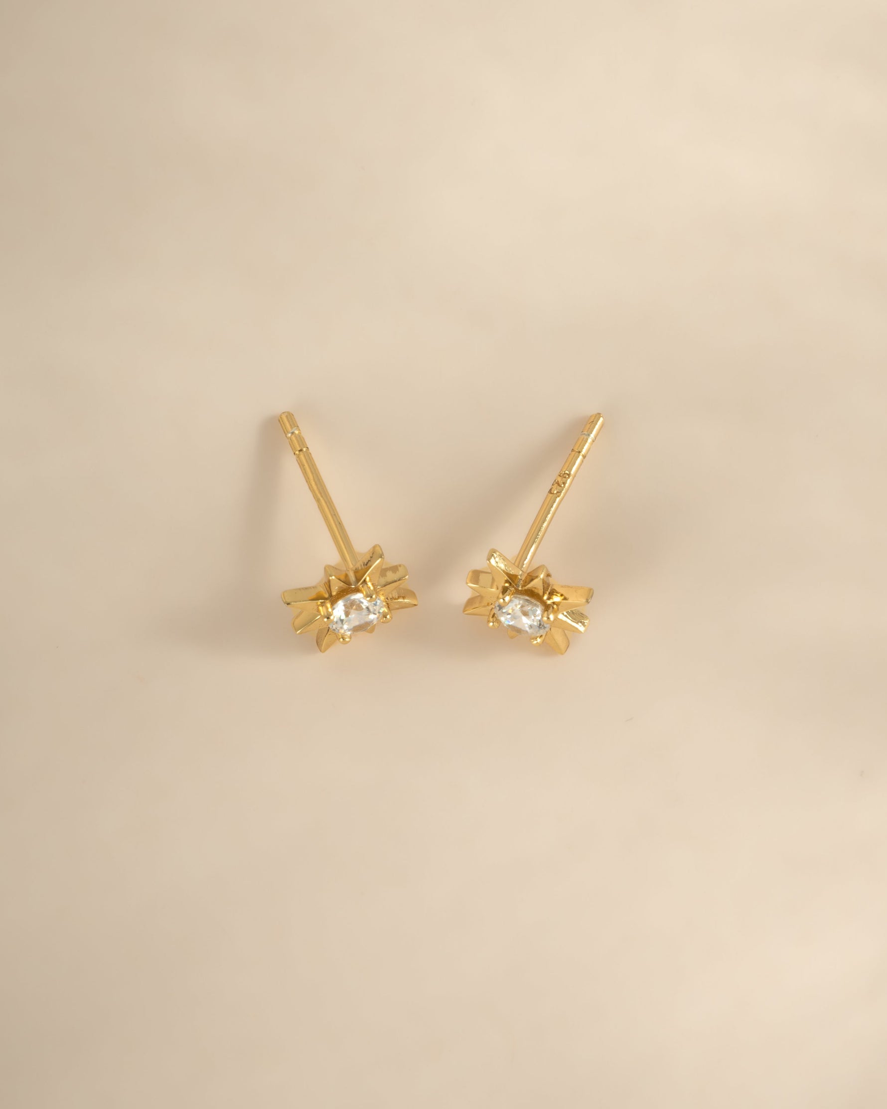 Gold starburst earrings from Sami Jewels, top view showing intricate design and shiny finish.