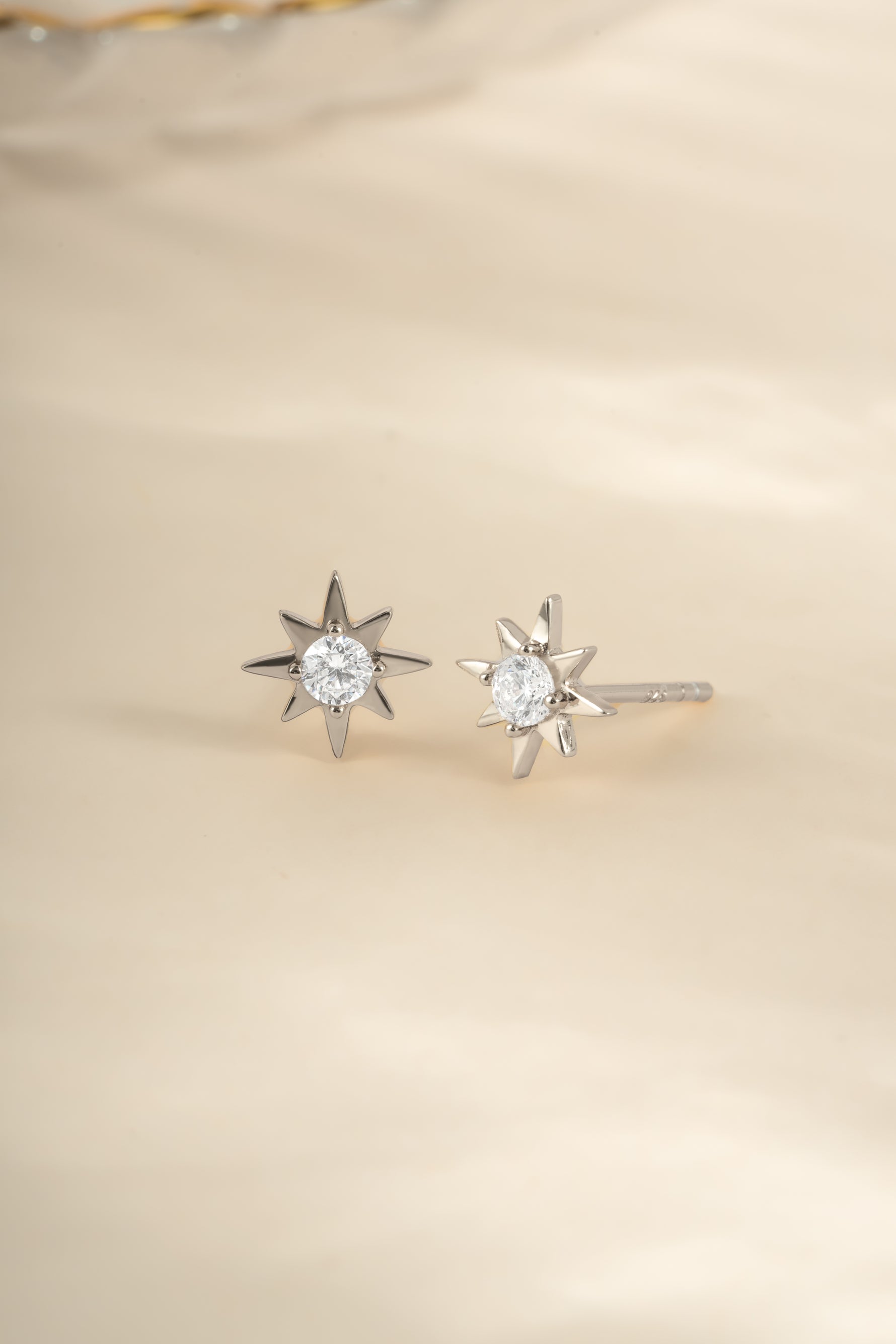 Sterling silver Starburst Earrings by Sami Jewels, angled view showing intricate design and shiny finish.