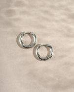 sterling silver 10mm hoop earrings on a neutral background