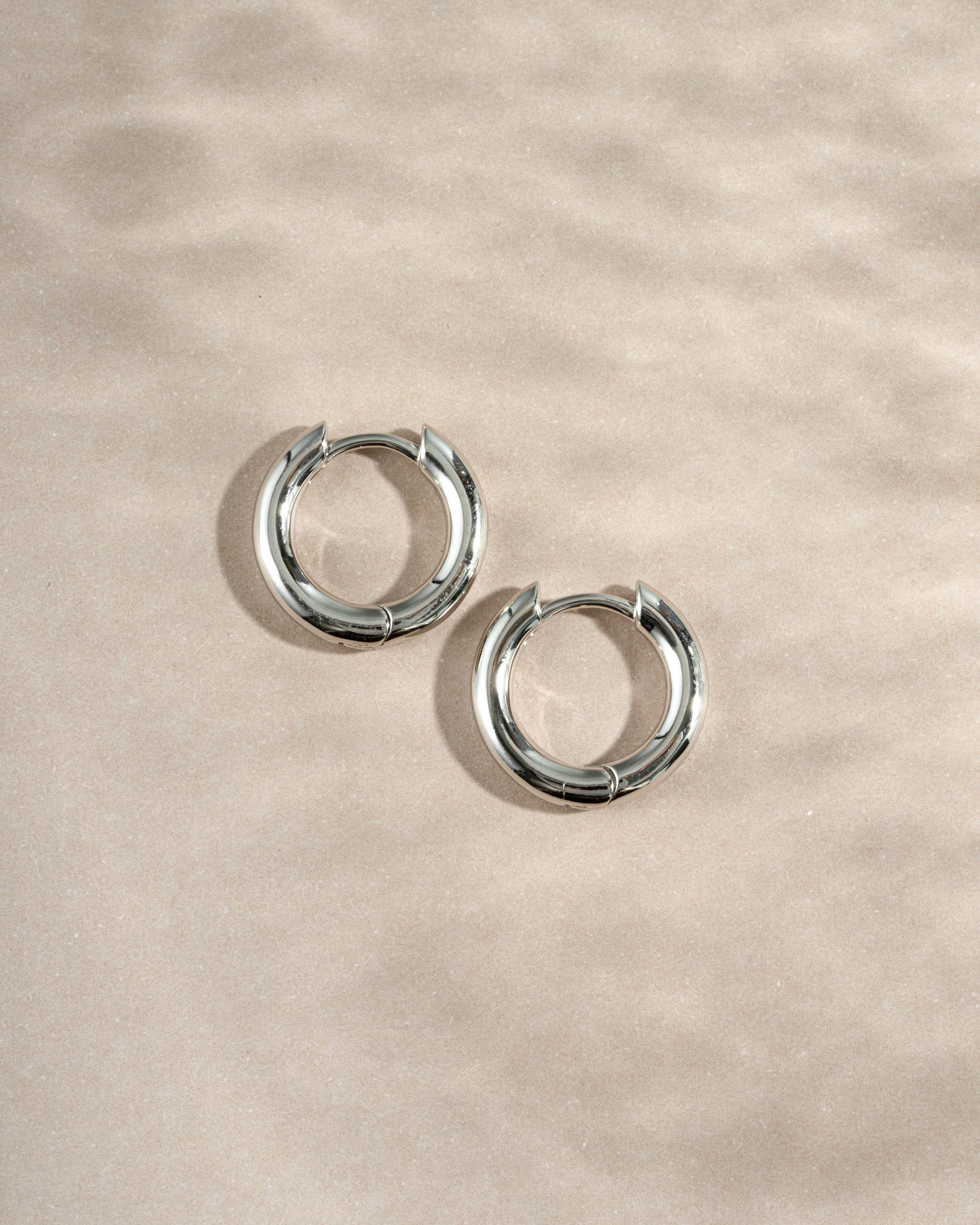 sterling silver 10mm hoop earrings on a neutral background