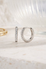 sterling silver 11mm studded huggie hoop neutral background