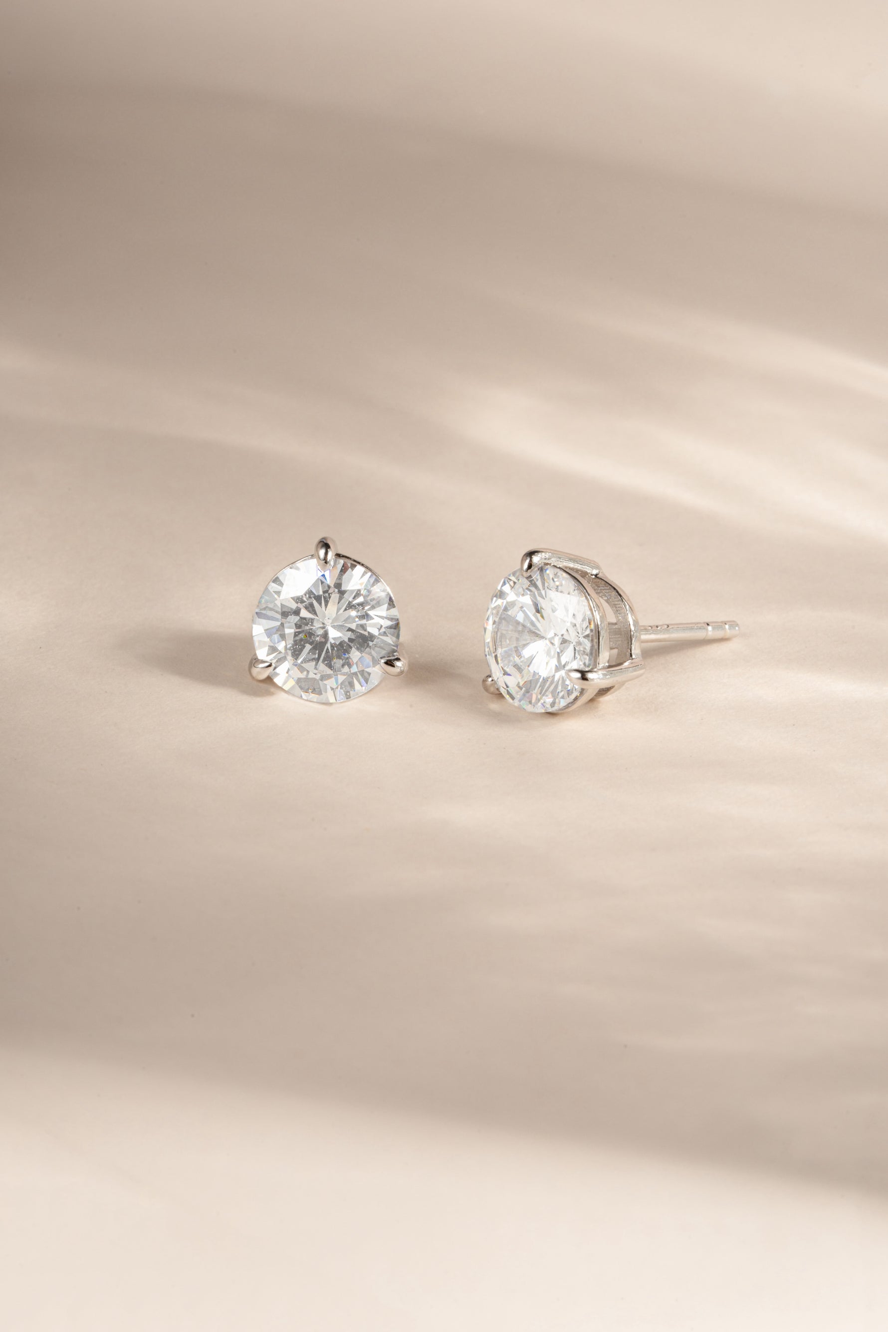 Sterling silver 7.5mm round solitaire diamond stud earrings by Sami Jewels, showcasing shiny, classic jewelry design.