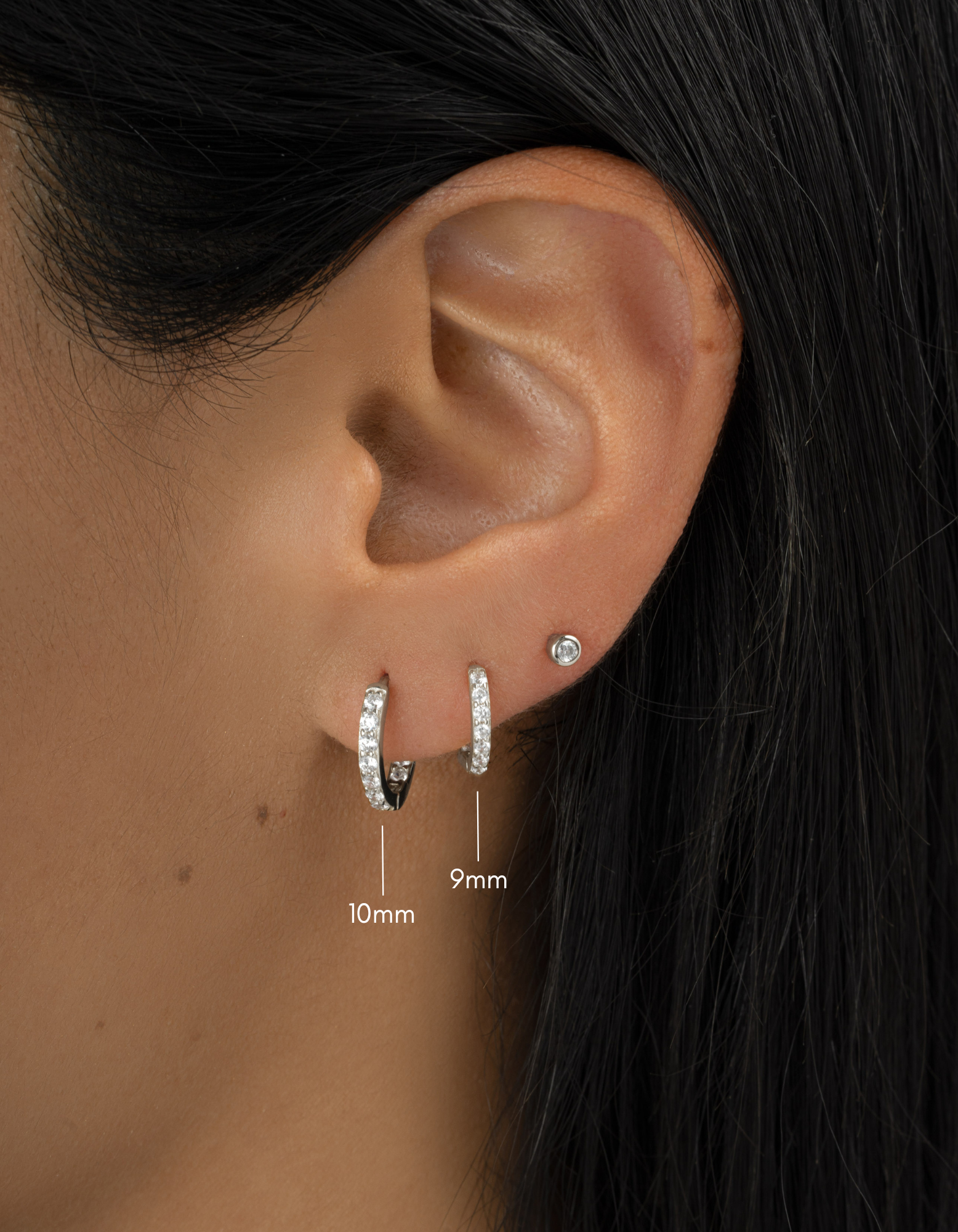 sterling silver in and out studded huggies on womens ear, one 10mm hoop, and one 9mm hoop