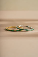 gold and sterling silver emerald birthstone eternity ring closeup